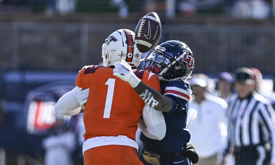 Liberty wide receiver DeMario Douglas, right, attempts to catch a past against Virginia Tech safety Charmarri Conner (1) during an NCAA college football game in Lynchburg, Va., Saturday, Nov. 19, 2022. (Paige Dingler/The News & Advance via AP)