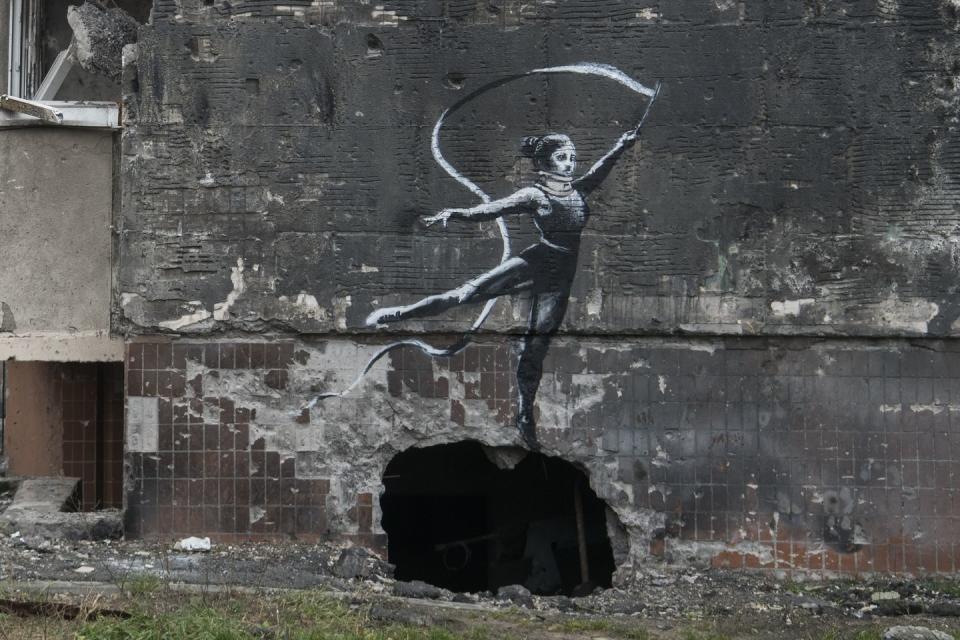 new graffiti in banksy style at the wall of destroyed residental buildings in the towns near kyiv