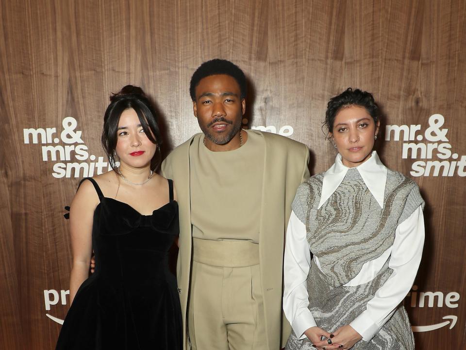 maya erskine, donald glover, and francesca sloane at the mr. and mrs. smith premiere in new york city, standing on a black carpet and posing in formal wear