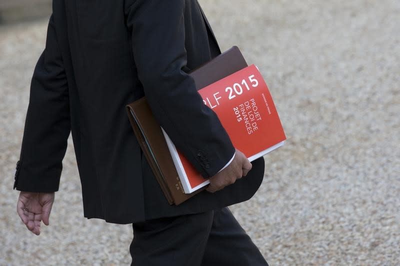 A government member holds a press release of France's 2015 Budget Project as he leaves following the weekly cabinet meeting at the Elysee Palace in Paris, October 1, 2014. REUTERS/Philippe Wojazer