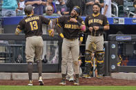 San Diego Padres' Manny Machado, left, celebrates his solo home run with Fernando Tatis Jr., center, during the seventh inning of a baseball game against the New York Mets at Citi Field, Sunday, June 13, 2021, in New York. San Diego Padres' Fernando Tatis Jr., right, hit a grand slam in the previous at bat. (AP Photo/Seth Wenig)