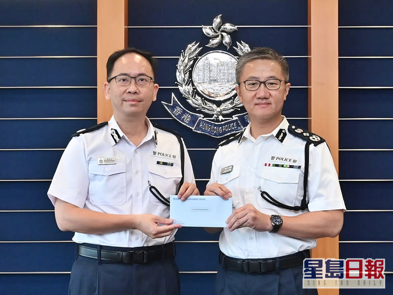 警務處處長蕭澤頤（右）頒授委任狀予新任香港輔助警察隊副總監梁世光（左）。政府新聞處圖片