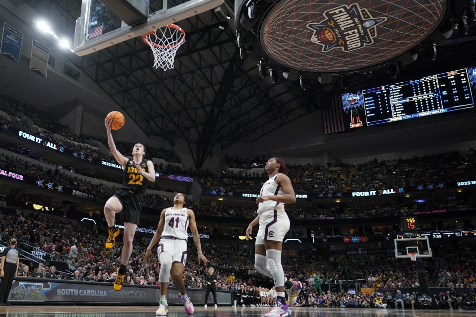 Iowa's Caitlin Clark shoots past South Carolina's Aliyah Boston and Kierra Fletcher during the first half of an NCAA Women's Final Four semifinals basketball game Friday, March 31, 2023, in Dallas. (AP Photo/Darron Cummings)