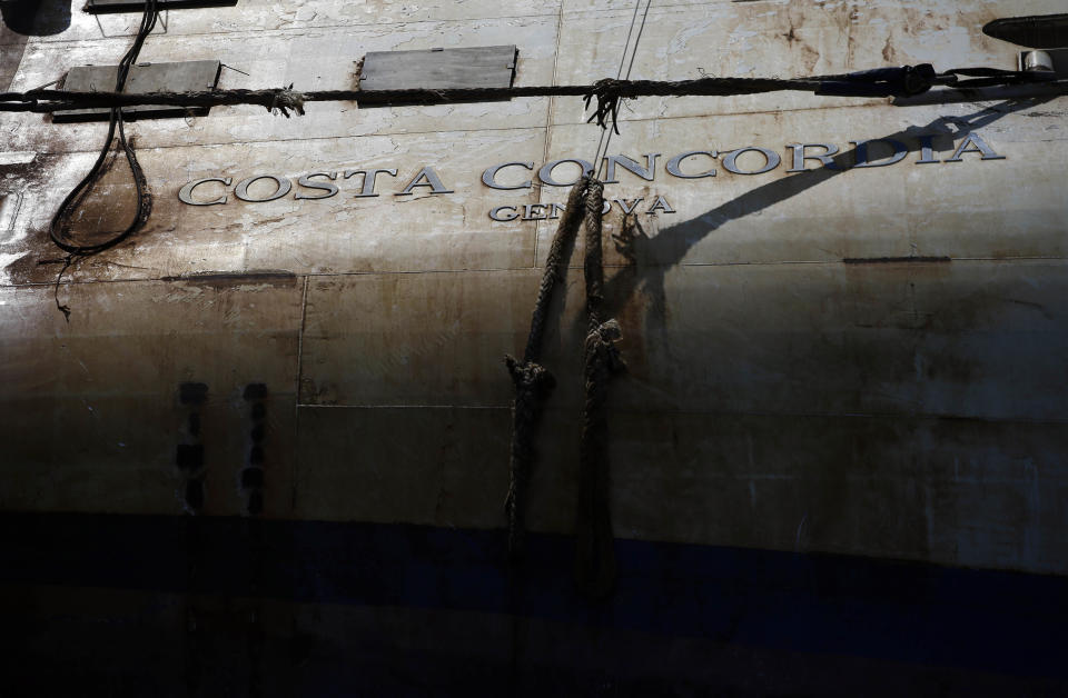 The Costa Concordia cruise ship lies on its side in the Tuscan Island of Isola del Giglio, Monday, July 15, 2013. Salvage crews are working against time to right and remove the shipwrecked Costa Concordia cruise ship, which is steadily compressing down on itself from sheer weight onto its granite seabed perch off the Tuscan island of Giglio. Salvage master Nick Sloane said Monday that the Concordia has compressed some 3 meters (10 feet) since it came to rest on the rocks Jan. 13, 2012 after ramming a jagged reef during a stunt ordered by the captain that cost the lives of 32 people. (AP Photo/Gregorio Borgia)