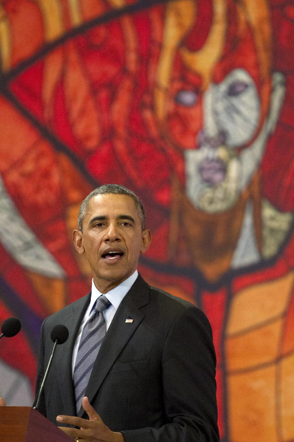 President Barack Obama speaks in front of a printed version of a stained glass window from the Cosmovitral, at a news conference at state government palace in Toluca, Mexico, Wednesday, Feb. 19, 2014, after the seventh trilateral North American Leaders Summit Meeting. This year's theme is “North American Competitiveness.” (AP Photo/Jacquelyn Martin)