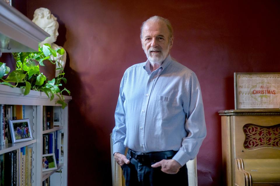 H Wayne Wilson stands in the parlor of his High Street home in Peoria. Wilson created WTVP's long-running news program At Issue and served as host for 35 years. He retired in August.