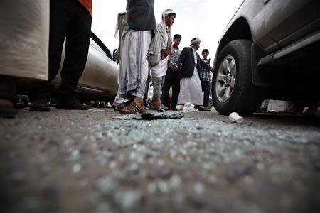 People gather around the car of the Shi'ite politician Ismail al-Wazir after an assassination attempt in Sanaa April 8, 2014. REUTERS/Khaled Abdullah
