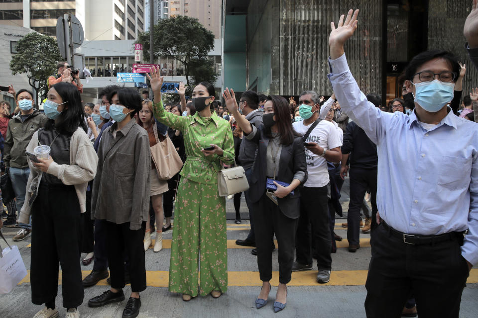 Protesters hold up their hands to symbolize pro-democracy demonstrators' five demands during a demonstration in the financial district in Hong Kong, Wednesday, Nov. 20, 2019. Hong Kong schools reopened Wednesday after a six-day shutdown but students and commuters faced transit disruptions as the last protesters remained holed up on a university campus. (AP Photo/Kin Cheung)