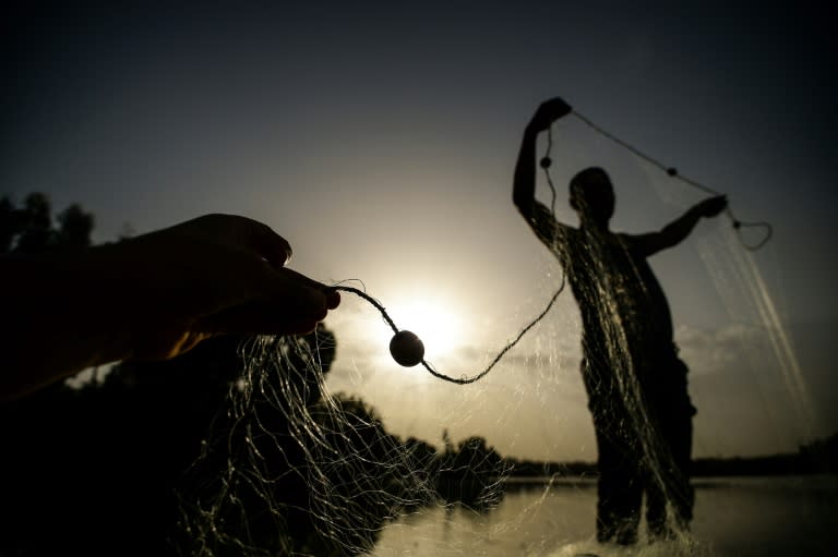 An Egyptian fisherman handles a net on his boat in the waters of the "Pharaonic Sea" on June 16, 2018