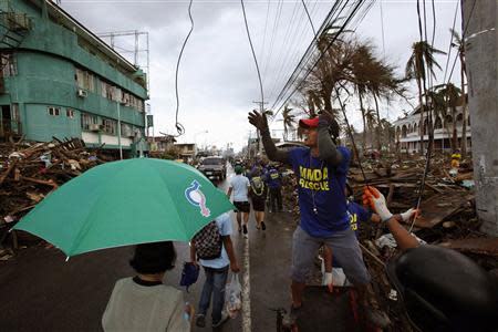 Workers clean up damaged electrical lines in the aftermath of super typhoon Haiyan in downtown Tacloban November 14, 2013. REUTERS/Bobby Yip