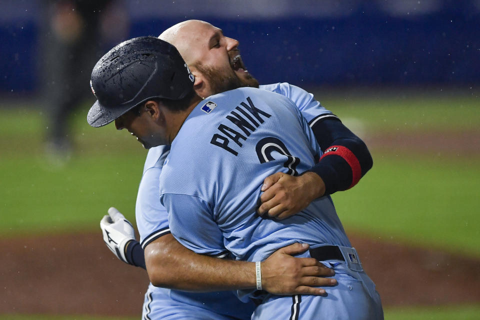 Toronto Blue Jays' Joe Panik, rear, is hugged by Rowdy Tellez after the Blue Jays defeated the Miami Marlins 6-5 in a baseball game in Buffalo, N.Y., Wednesday, June 2, 2021. (AP Photo/Adrian Kraus)