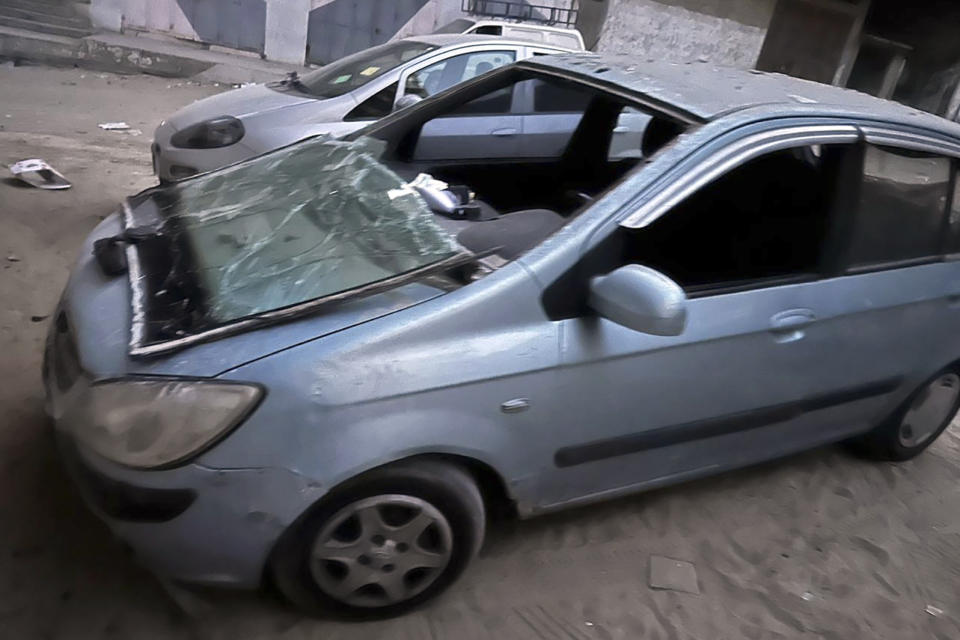 This photo provided by Hosein Owda shows damage to his car pulled out from the rubble in Gaza on Oct. 11, 2023. Owda and his family were sheltering with relatives in Gaza city soon after the war in Gaza began following the stunning Hamas attack on Israel on Oct. 7, when a bomb hit near their house, driving them out and damaging his car. Owda, a UN worker, now lives among thousands of displaced Palestinians after losing his Gaza City apartment early in the war. (Hosein Owda via AP)