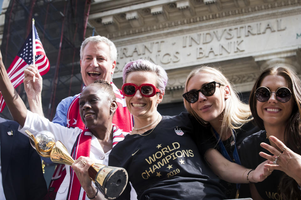 Megan Rapinoe #15 of United States holds the 2019 FIFA World Cup Champion Trophy with Alex Morgan #13 of United States and Allie Long #20 of United States, Mayor Bill De Blasio, and his wife Chirlane McCray ride on the World Champions float as it rides down Broadway for the Ticker Tape through the Canyon of Heroes. This celebration was put on by the City of Manhattan to honor the team winning the 2019 FIFA World Cup Championship title, their fourth, played in France against Netherlands, at the City Hall Ceremony in the Manhattan borough of New York on July 10, 2019, USA. (Photo by Ira L. Black/Corbis via Getty Images)