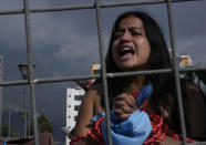 An abortion-rights activist takes in a demonstration outside the National Assembly as lawmakers vote on whether to allow abortion in all cases of rape, in Quito, Ecuador, Thursday, Feb. 17, 2022. Currently, abortion is legal in Ecuador if the mother's life is in danger or in cases involving the rape of a woman with a mental disability. (AP Photo/Dolores Ochoa)