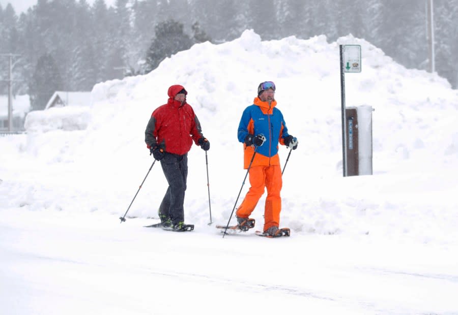 Brothers Bob and Ron Barrett, of Klamath Falls, from left, snowshoe in downtown Truckee, Calif., on Saturday, March 2, 2024. They couldn’t get their truck out of a nearby parking lot because of all of the snow. (Jane Tyska/Bay Area News Group via AP)