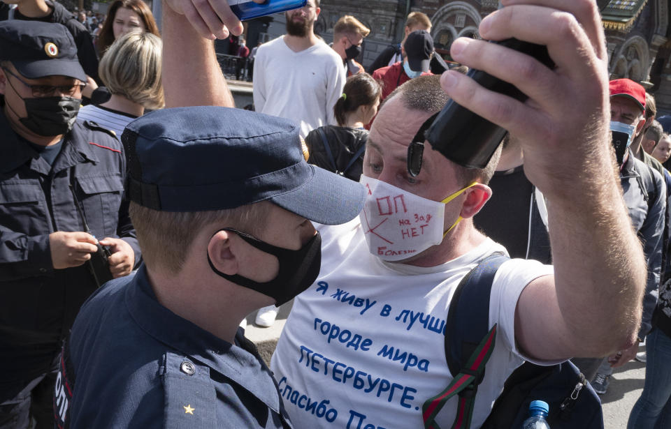 A protester argues with a policeman during a rally supporting Khabarovsk region's governor Sergei Furgal in St.Petersburg, Russia, Saturday, Aug. 1, 2020. Thousands of demonstrators rallied Saturday in the Russian Far East city of Khabarovsk to protest the arrest of the regional governor, continuing a three-week wave of opposition that has challenged the Kremlin. (AP Photo/Dmitri Lovetsky)