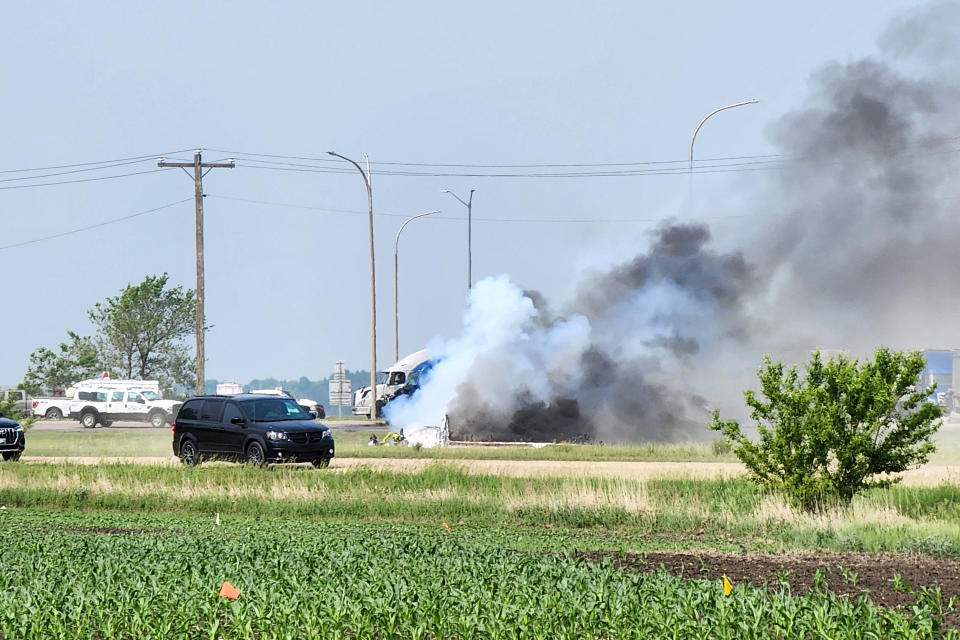 Smoke comes out of a car following a road accident that left 15 dead near Carberry, west of Winnipeg, Canada on June 15, 2023. At least 15 people died June 15, 2023 in a road accident in central Canada's Manitoba province, local media reported. Canadian police said on Twitter that officers were responding to a "mass casualty collision" near the town of Carberry, west of Winnipeg, and that first responders and other Royal Canadian Mounted Police units were on the scene. (Photo by Nirmesh VADERA / AFP) (Photo by NIRMESH VADERA/AFP via Getty Images)