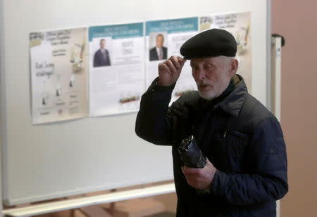 A man walks past election posters during a general election run-off in Birzai, Lithuania, October 23, 2016. REUTERS/Ints Kalnins