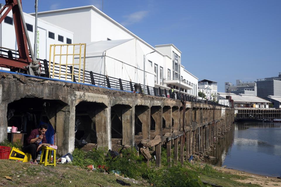 Carlos Ibáñez desayuna en la zona donde vive, bajo el edificio del Puerto recientemente remodelado, que albergará la próxima 64ª Cumbre del Mercosur, en Asunción, Paraguay, el 6 de julio de 2024. (Foto AP/Jorge Sáenz)