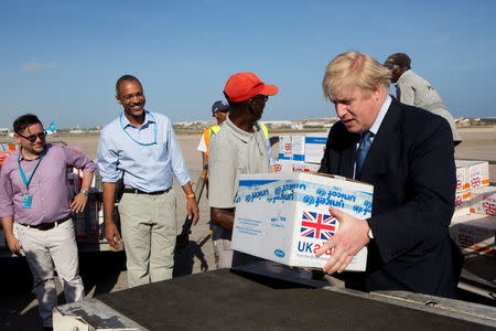 Britain's Foreign Secretary Boris Johnson helps to load supplies for treating malnourished children affected by the severe drought in Somalia onto a cargo plane at Mogadishu International Airport in Mogadishu, Somalia March 15, 2017. REUTERS/Karel Prinsloo/UNICEF/Handout via REUTERS