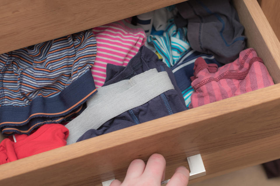 Person öffnet eine Unterwäscheschublade mit bunter Unterwäsche