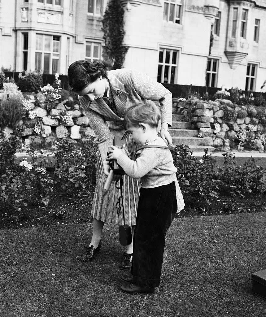 Queen Elizabeth II helping Prince Charles with a camera in the grounds of Balmoral Castle, Scotland, 28th September 1952. (Photo by Lisa Sheridan/Hulton Archive/Getty Images)