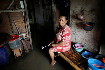 Sainah sits in the kitchen area of her home, flooded by sea water, near Pantai Bahagia in Bekasi, West Java province, Indonesia, February 1, 2018. REUTERS/Darren Whiteside