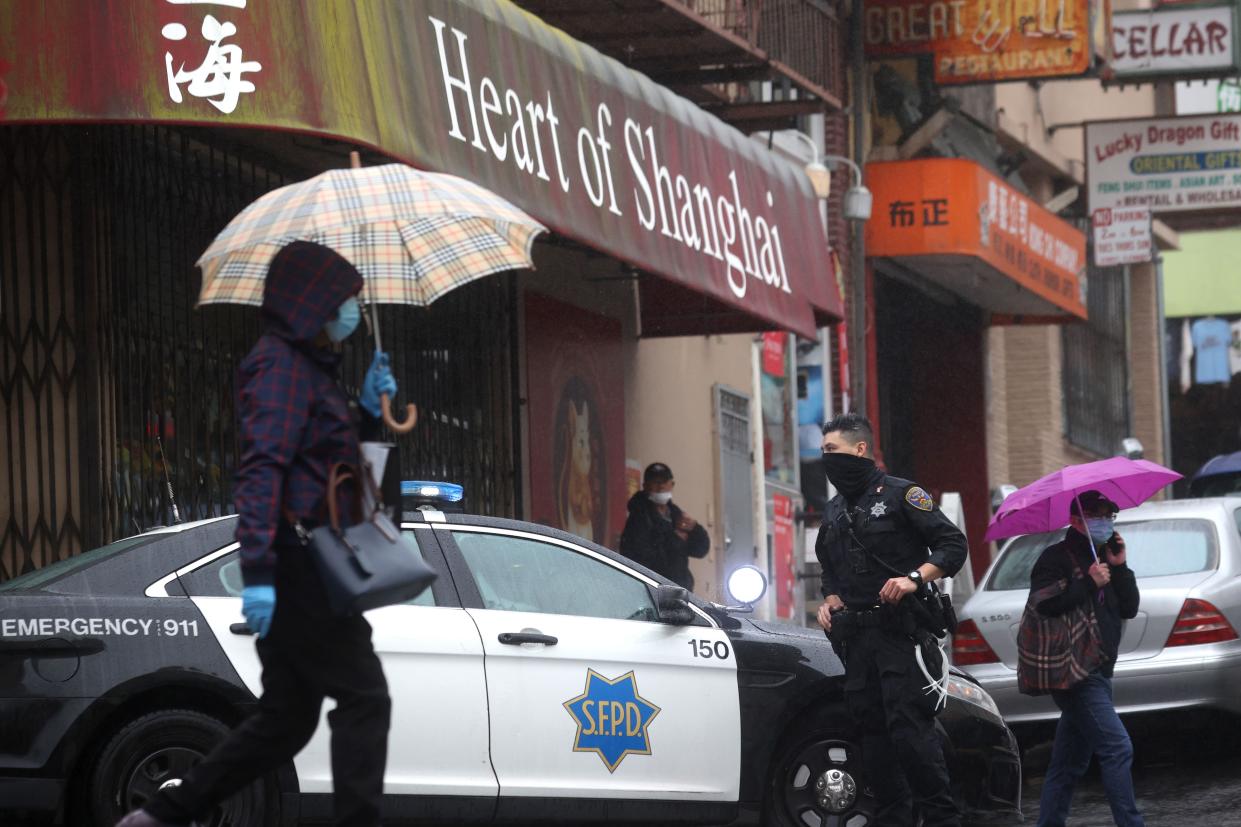 San Francisco police officer stands guard on a street corner in Chinatown in San Francisco, California.