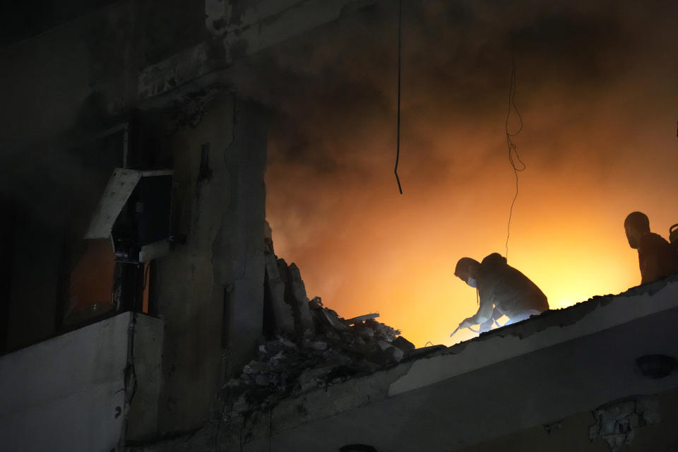 A man tries to extinguish the fire inside an apartment following a massive explosion in the southern suburb of Beirut, Lebanon, Tuesday, Jan. 2, 2024. The TV station of Lebanon's Hezbollah group says top Hamas official Saleh Arouri was killed Tuesday in an explosion in a southern Beirut suburb. (AP Photo/Hussein Malla)