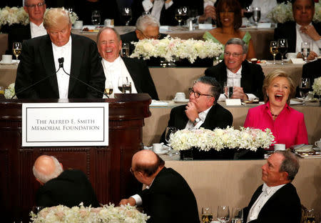 Hillary Clinton laughs at a joke by Donald Trump. REUTERS/Jonathan Ernst