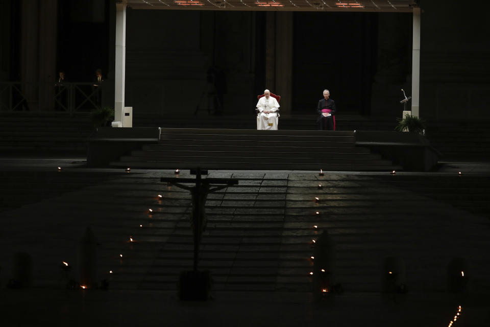 Pope Francis is flanked by Mons. Guido Marini, right, the Vatican master of liturgical ceremonies, as he leads the Via Crucis – or Way of the Cross – ceremony in St. Peter's Square empty of the faithful following Italy's ban on gatherings to contain coronavirus contagion, at the Vatican, Friday, April 10, 2020. (AP Photo/Alessandra Tarantino)