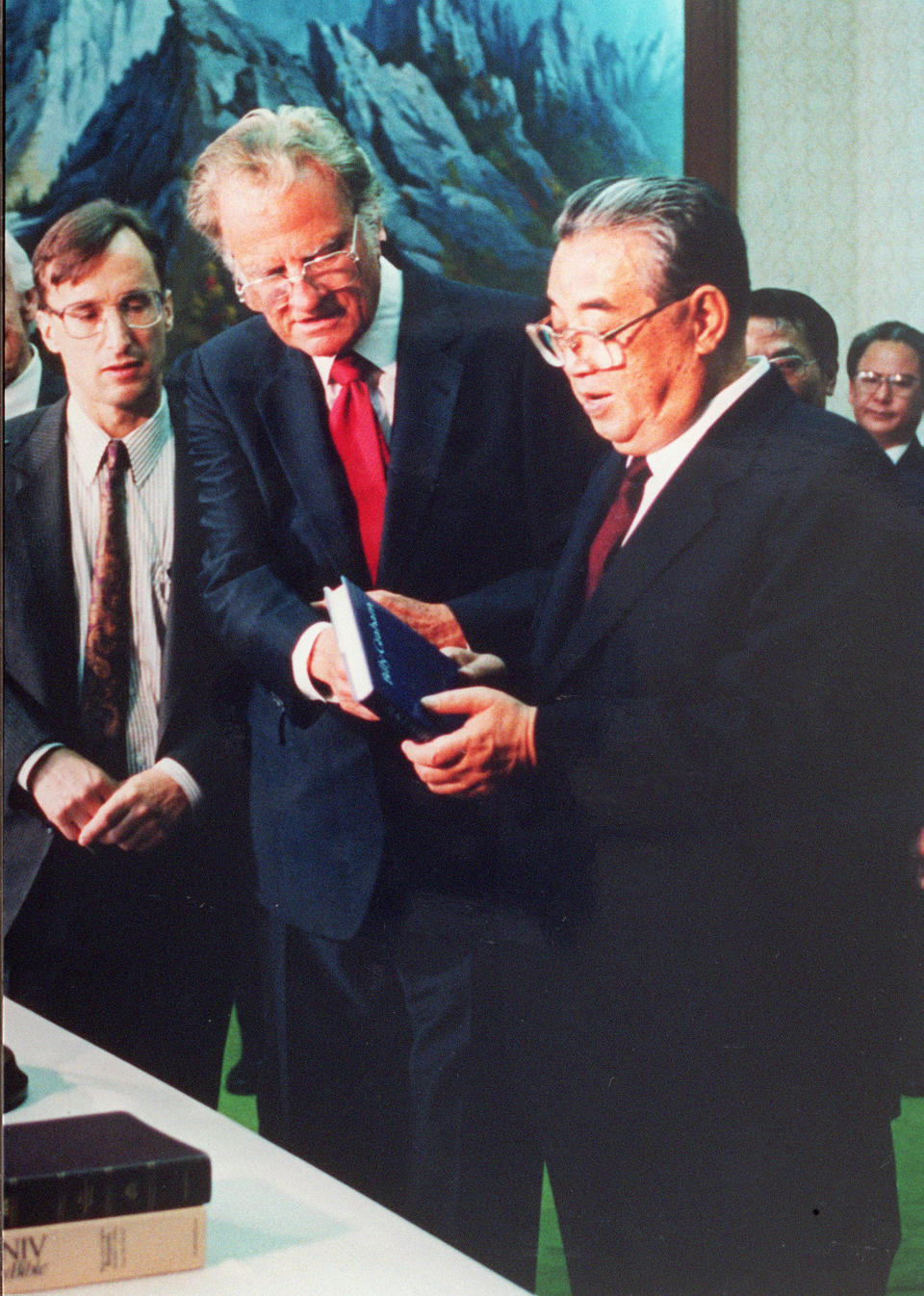 PYONGYANG, SOUTH KOREA:  Billy Graham (C), the American evangelist, presents his book 'Peace with God' to North Korean President Kim il-Sung (R) 02 April 1992 in Pyongyang. Graham, (son of a dairy farmer, born in 1918 in Charlotte, NC), attended Florida Bible Institute and was ordained a Southern Baptist minister in 1939 and quickly gained a reputation as a preacher. During the 1950s he conducted a series of highly organized revivalist campaigns in the USA and UK, and later in South America, the USSR and Western Europe. (Photo credit should read AFP/Getty Images)