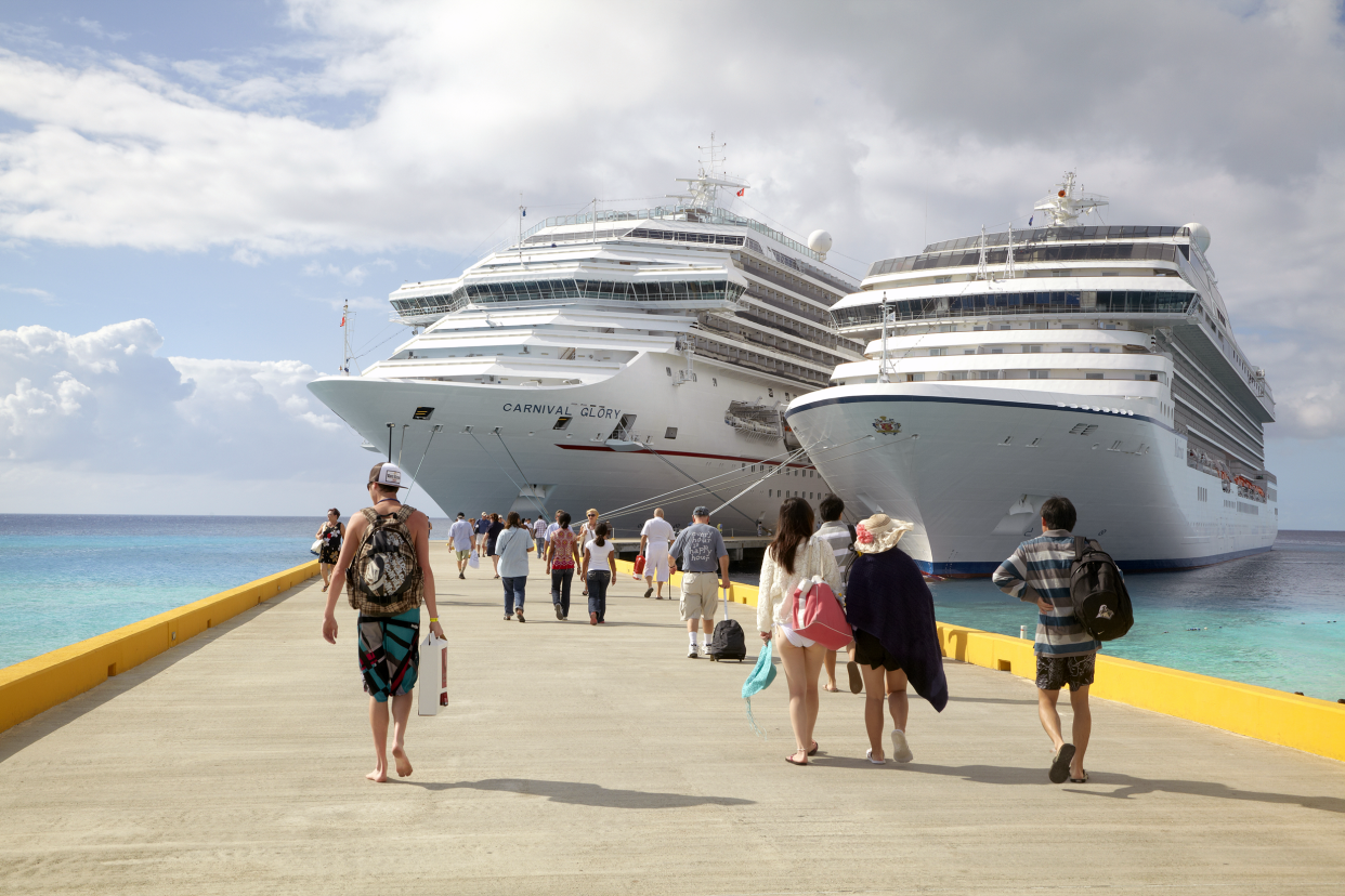 People getting back onto a cruise shop at a dock