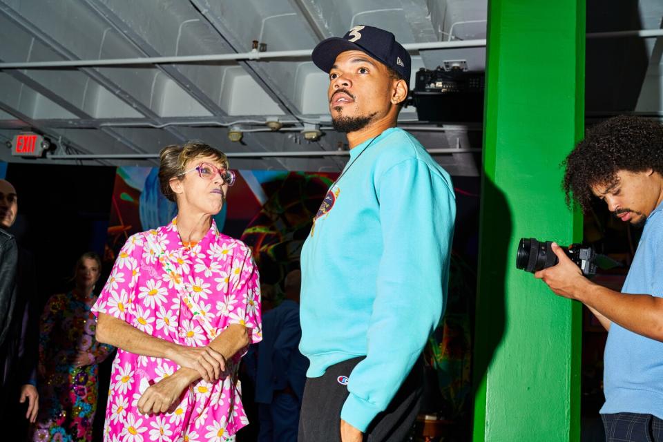 A man, a woman, and a photographer stand in an exhibit.