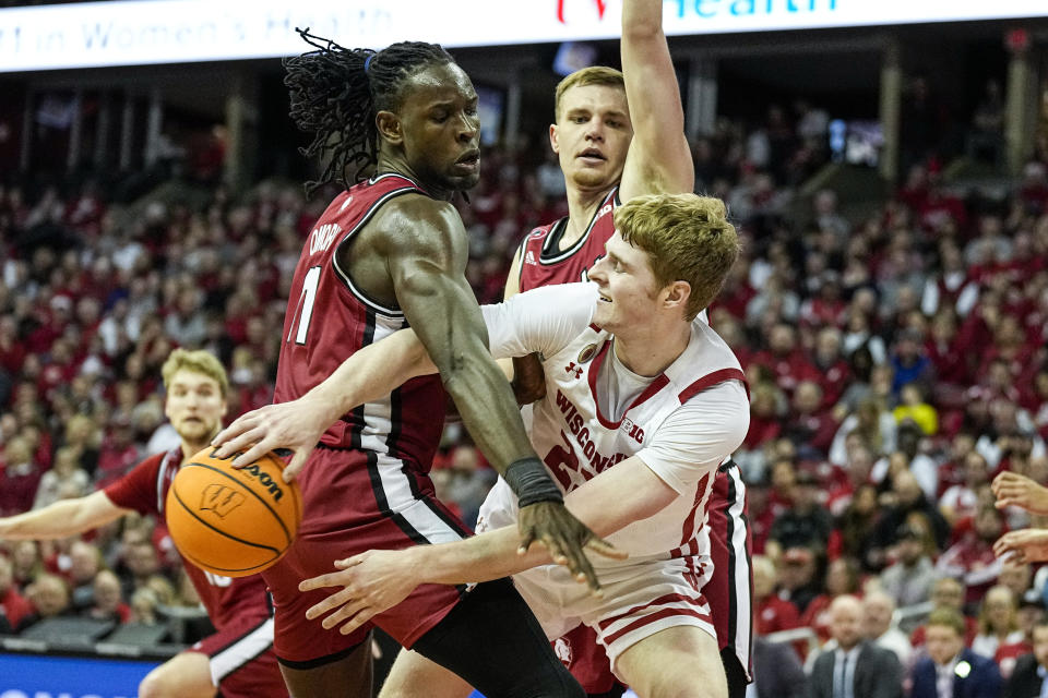 Wisconsin's Steven Crowl (22) passes as Rutgers' Clifford Omoruyi, left, Oskar Palmquist defend during the second half of an NCAA college basketball game Saturday, Feb. 18, 2023, in Madison, Wis. (AP Photo/Andy Manis)