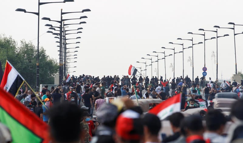 Iraqi security forces stand in front of demonstrators during a protest over corruption, lack of jobs, and poor services, in Baghdad