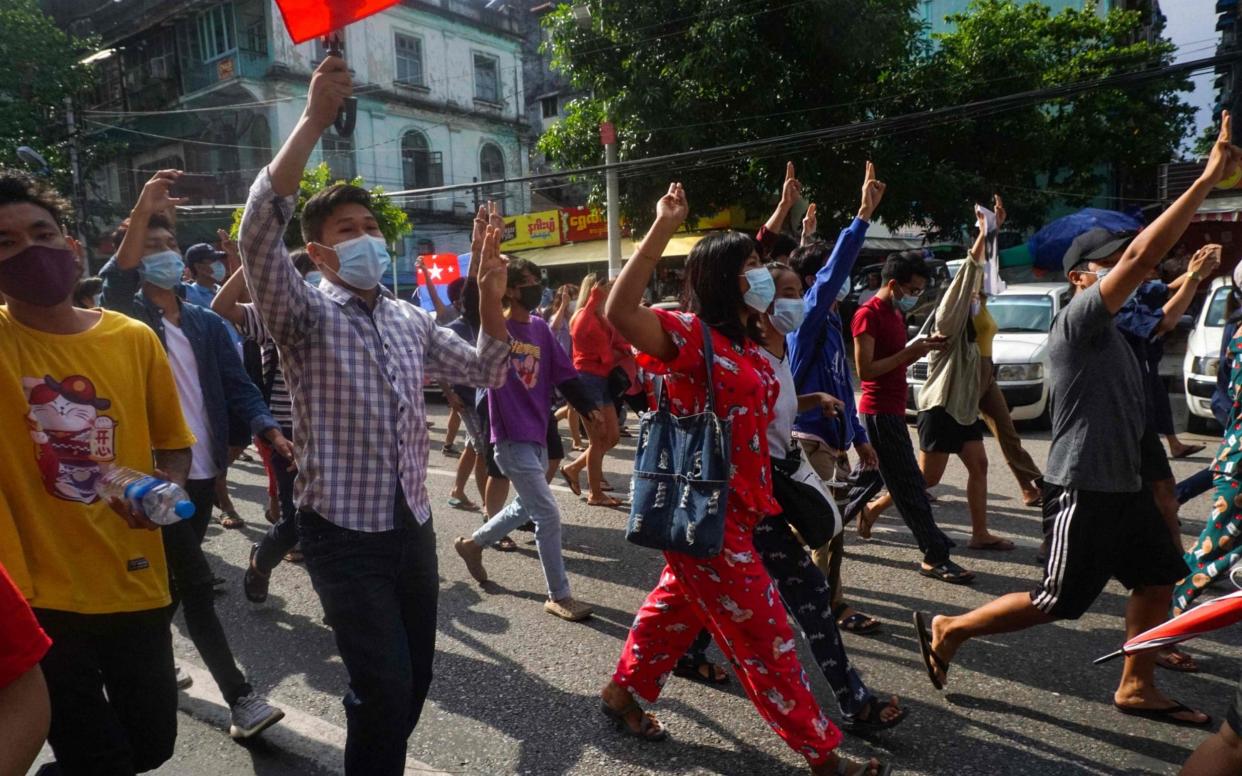 Protesters make the three-finger salute during a demonstration against the military coup in downtown Yangon - STR /AFP