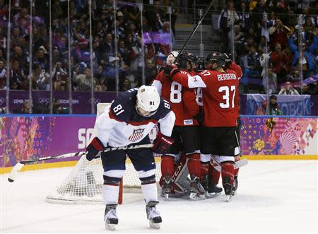 Canada celebrates their men's ice hockey semi-final win as Team USA's Phil Kessel (L) skates away at the Sochi 2014 Winter Olympic Games February 21, 2014. REUTERS/Phil Noble