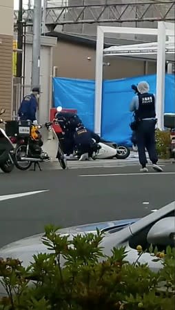 Police attend to the scene of a stabbing attack on a Japanese police officer near a police box in Suita, Japan in this still frame taken from social media video dated June 16, 2019