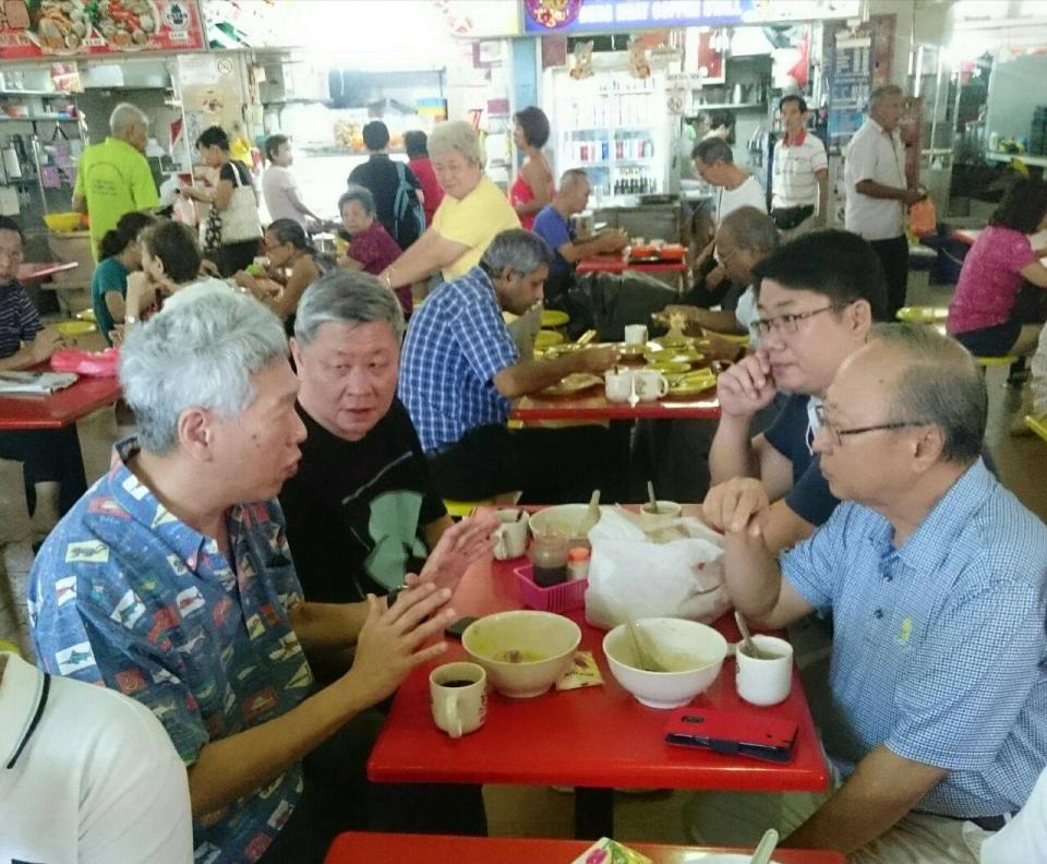 Tan Cheng Bock (foreground, right) and Lee Hsien Yang (foreground, left) seen having breakfast at a West Coast hawker centre in November 2018. FILE PHOTO: Yahoo News Singapore