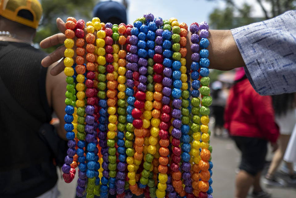 Un vendedor ofrece collares con los colores del arco iris durante el desfile anual del Orgullo Gay que marca la culminación del mes del Orgullo LGBTQ+, el sábado 29 de junio de 2024, en la Ciudad de México. (Foto AP/Jon Orbach)