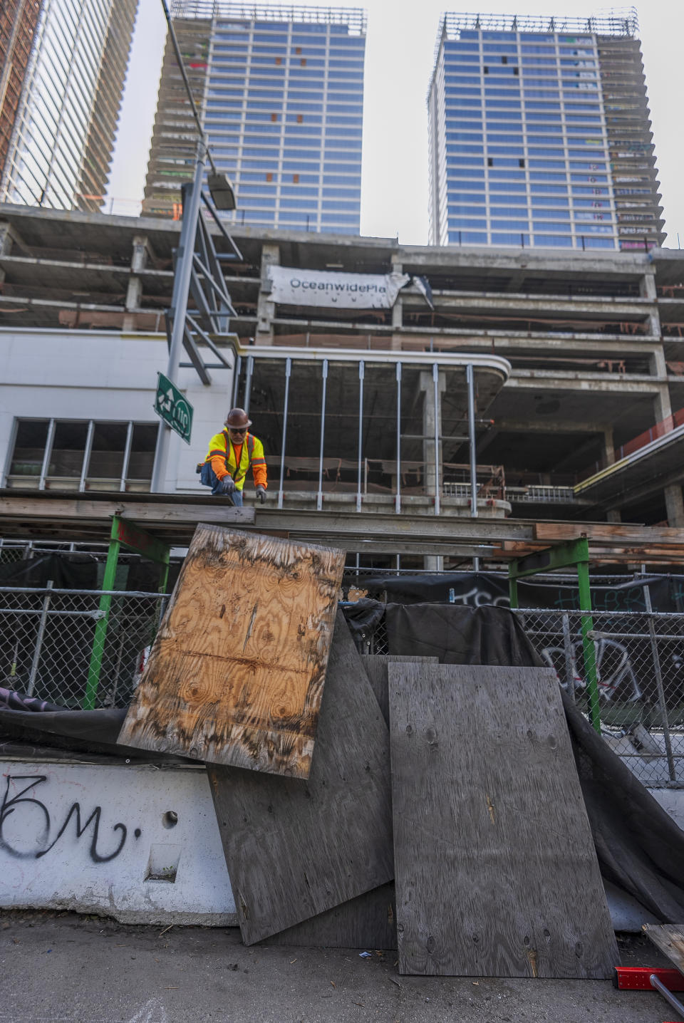 Crews begin removing scaffolding protecting a temporary walkway that officials say said has helped helped trespassers enter an unfinished complex of downtown Los Angeles that have recently been vandalized with graffiti and used for dangerous social media stunts in Los Angeles Friday, Feb. 16, 2024. (AP Photo/Damian Dovarganes)