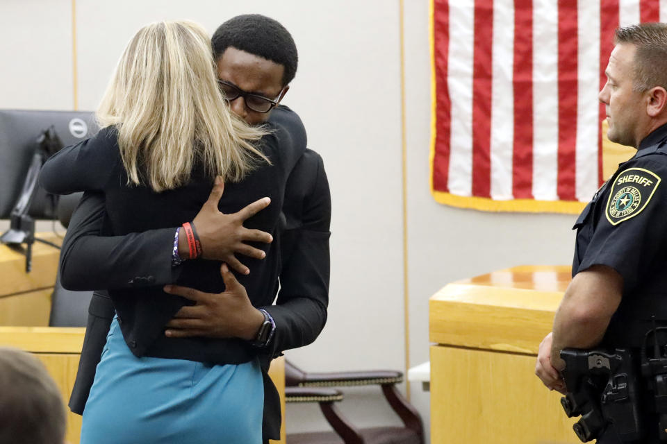 Botham Jean's younger brother Brandt Jean hugs convicted murderer and former Dallas Police Officer Amber Guyger after delivering his impact statement to her after she was sentenced to 10 years in jail, Wednesday, Oct. 2, 2019, in Dallas. Guyger shot and killed Botham Jean, an unarmed 26-year-old neighbor in his own apartment last year. She told police she thought his apartment was her own and that he was an intruder. (Tom Fox/The Dallas Morning News via AP, Pool)