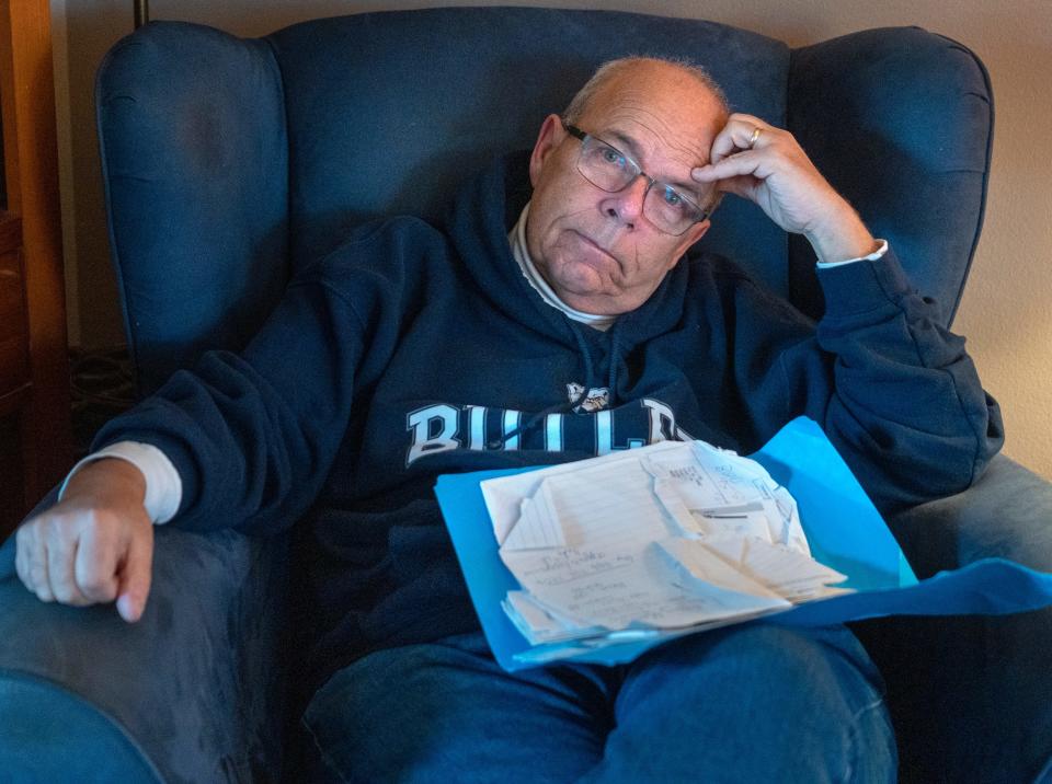 Marty Weyand shows papers and documents he accumulated while working through guardianship issues placed on his late father by the nursing home where he lived. Photo taken Tuesday, March 19, 2024 at his home in Speedway.