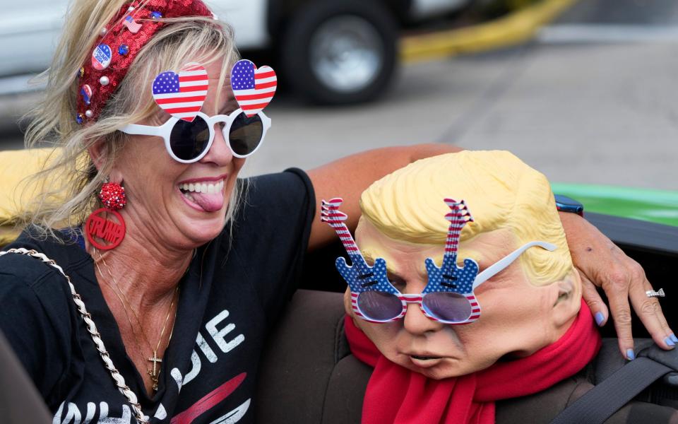 Michelle Lilly, a Trump supporter, poses with a mask wearing novelty glasses - Wilfredo Lee