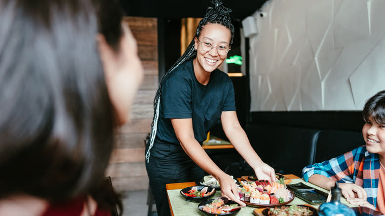 waiter serving food in Japanese restaurant