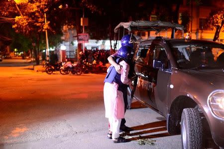 A wounded police personnel is helped by a colleague, after gunmen stormed the Holey Artisan restaurant and took hostages, in the Gulshan area of Dhaka, Bangladesh July 1, 2016. Courtesy of Dhaka Tribune/Mahmud Hossain Opu/via REUTERS