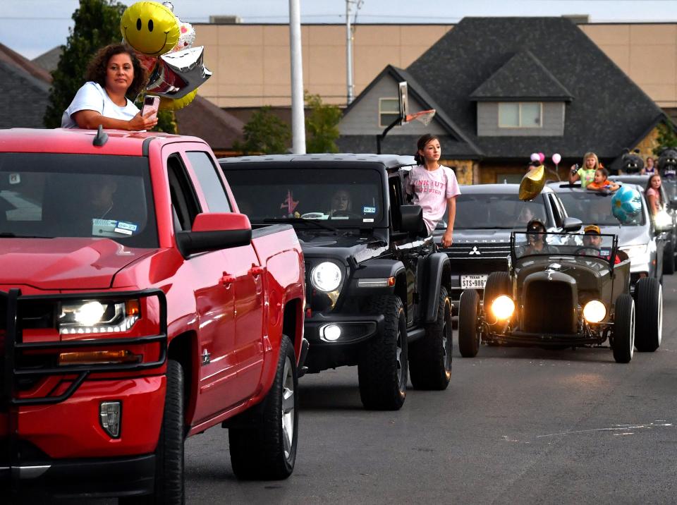 Participants proceed down the street outside the Molina home in south Abilene during Tuesday’s parade.