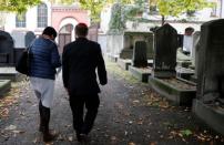 People walk in a cemetery at the synagogue in Halle