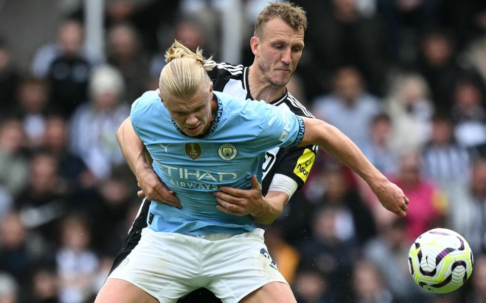 Manchester City's Norwegian striker #09 Erling Haaland (L) and Newcastle United's English defender #33 Dan Burn (R) fight for the ball during the English Premier League football match between Newcastle United and Manchester City at St James' Park in Newcastle-upon-Tyne